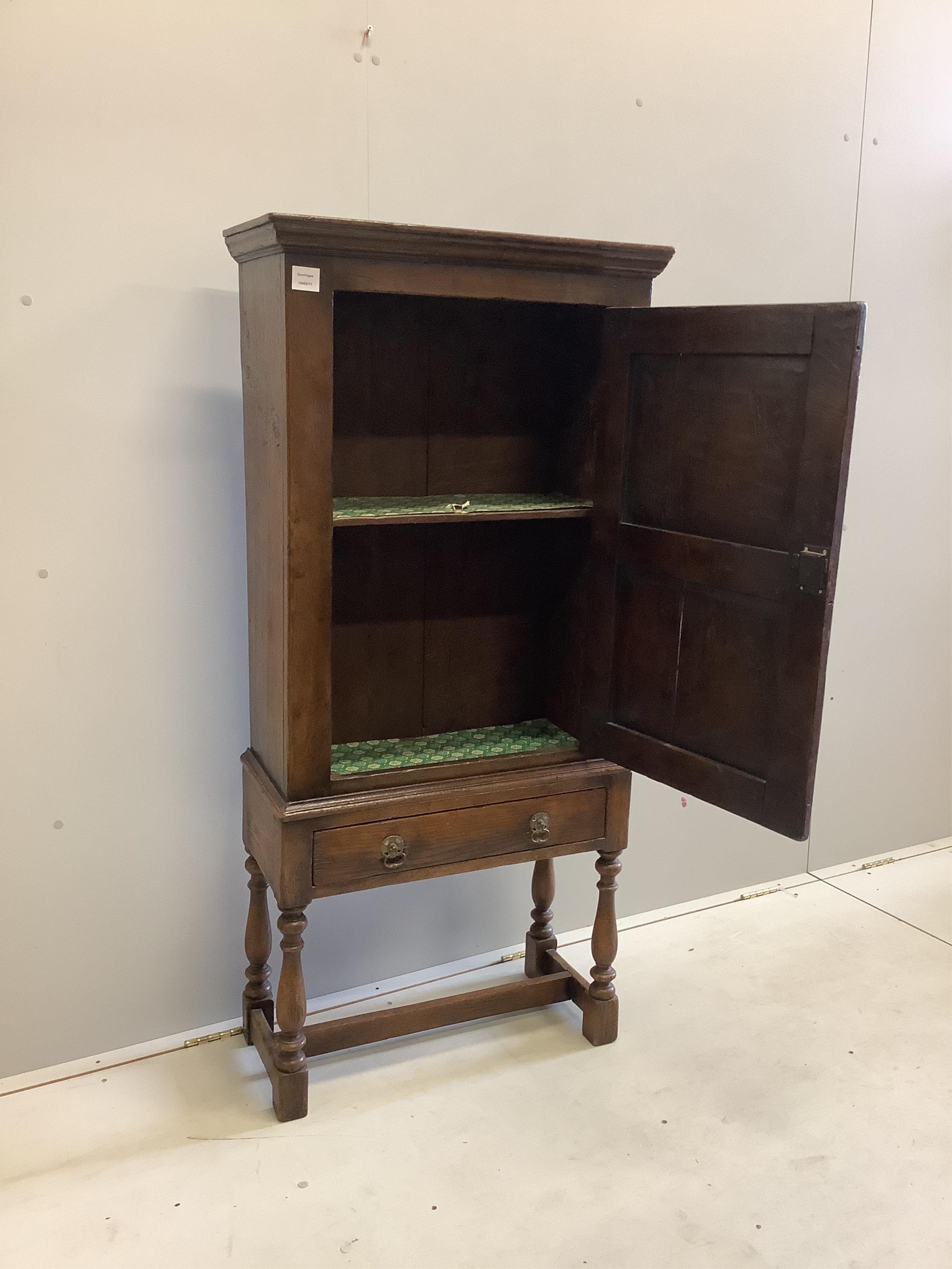 A 17th century style oak cupboard on stand, width 67cm, depth 29cm, height 143cm. Condition - good